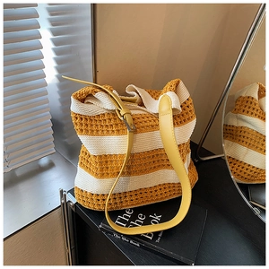 Detail of yellow and white striped crochet tote bag with adjustable leather strap