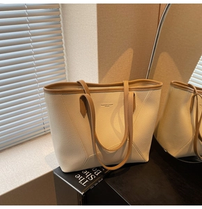 Detail of minimalist tote bag with off-white lychee grain leather and brown contrast trim