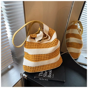 Detail of hollow knit tote bag with yellow stripes and leather shoulder strap