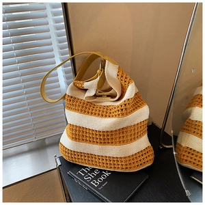 Detail of yellow and white striped knit hobo bag with delicate openwork crochet texture