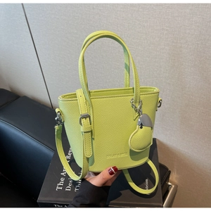 Close-up of light green litchi grain leather bucket bag with heart charm and silver logo