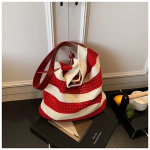 Detailed knit texture of red and white striped tote bag with red leather straps