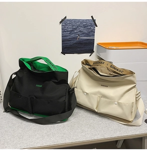 Détail de grands sacs bandoulière en toile avec doubles poches avant et larges bandoulières