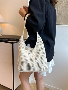 Chic cream crochet bucket bag with hollow knit patterns for a beach vacation style