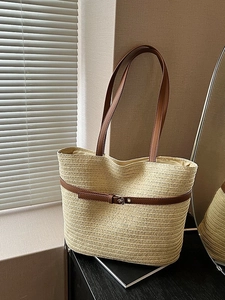 Beige woven straw tote bag with brown leather straps and metal buckles for summer beach