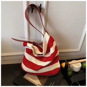 Detail view of red and white striped crochet tote bag with premium leather shoulder strap