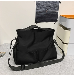 Détail du grand sac cabas noir avec bandoulières et poches multiples pratiques