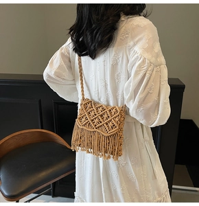 Détail du sac en paille bohème avec motif de tissage en losange et longues franges pendantes