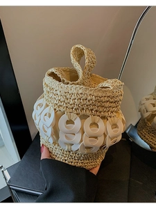 Handmade woven bucket bag with white ring accents and natural straw texture for women