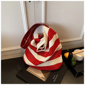 Close-up of red and white striped knit tote with adjustable leather shoulder strap