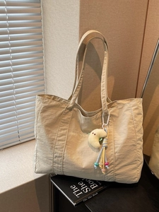 Minimalist beige canvas tote bag with moon plush charm and tassel for daily commuting