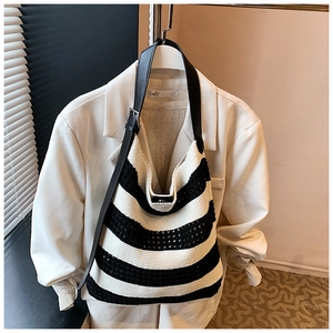 Detail of black and white striped knit tote bag with premium leather shoulder strap