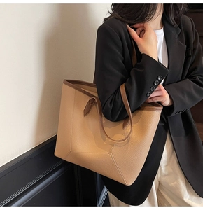 Detail of minimalist large capacity tote bag with brown pebbled leather texture on model