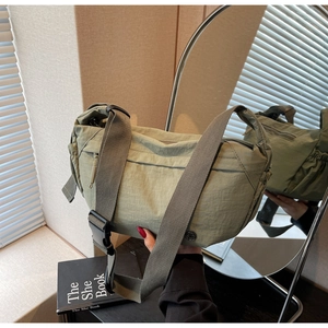 Detail of olive green nylon crossbody bag with wide strap and adjustable buckle