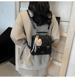Details des schwarzen Vintage-Rucksacks mit Hirschprint und gelbem Bären-Plüschanhänger