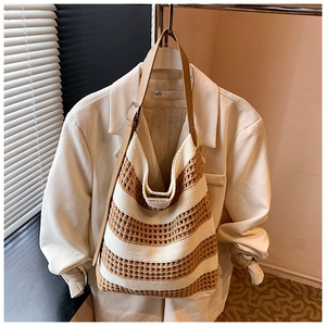 Detail of knit tote bag showing beige striped mesh texture and brown leather strap