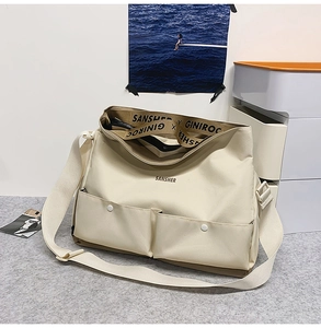 Détail du sac fourre-tout en toile montrant deux poches avant et la bandoulière SANSHER