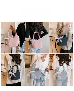 Détail du sac cabas tissé avec nœud en dentelle et perle en rose, noir et bleu