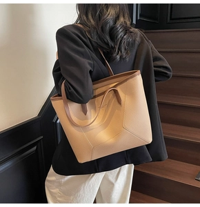 Detailed view of the large beige tote bag with brown straps and pebble leather texture