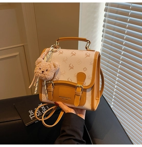 Detail der Handtasche mit Hirschprint, funktionellen Schnallen und Plüschbär-Anhänger