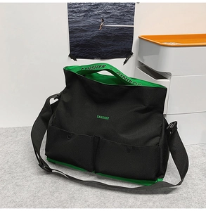 Détail du sac bandoulière en toile avec doublure verte, doubles poches et sangle réglable