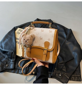 Detailansicht der Canvas- und Ledertasche mit Elch-Print und plüschigem Bären-Anhänger