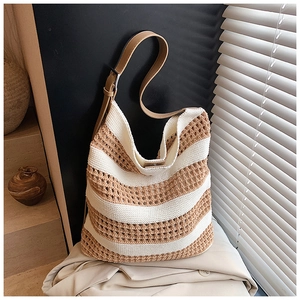 Detail view of hollow crochet texture and khaki stripes on a knitted tote bag