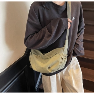 Model wearing a light green nylon dumpling bag with adjustable shoulder strap details