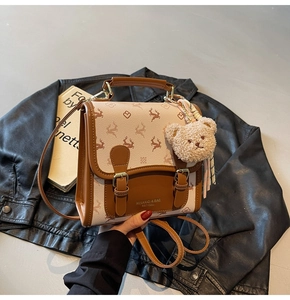 Nahaufnahme von Vintage-Lederrucksack mit floralem Muster und Plüschbär-Anhänger