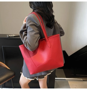 Detail of red large capacity tote bag with lychee texture and geometric tailoring