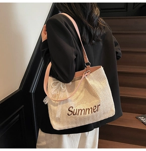 Detail of straw tote bag with Summer embroidery, pink strap and lace pearl charm