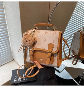 Detail der creme-braunen Tasche mit Elchmuster und einem süßen braunen Plüschbären
