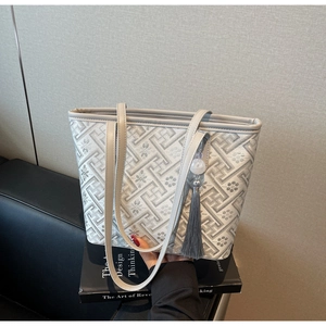 Dettaglio della borsa tote jacquard grigia con elegante nappa e spalline sottili