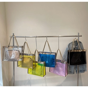 Detail of transparent PVC tote bag featuring rustic rope handles and an inner pouch