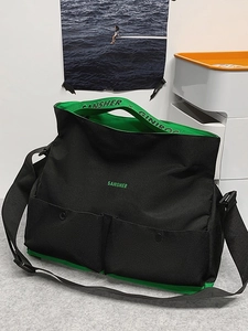 Grand sac de voyage en toile noir et vert avec bandoulière réglable et poches frontales