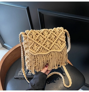 Close-up of handmade beige macrame bag featuring intricate weave patterns and long tassels