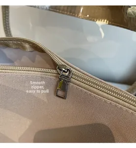 Detailed macro view of the smooth metal zipper and durable fabric on beige tote bag
