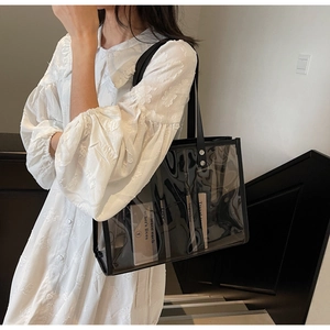 Détail du grand sac cabas transparent en PVC avec bordure noire et rivets en métal