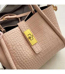Dettaglio borsa rosa con stampa coccodrillo e chiusura a girello rettangolare oro