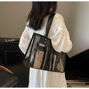 Vue détaillée du sac cabas transparent en PVC avec bordure noire et bandoulière chic