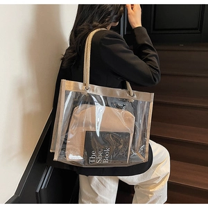 Detail of transparent PVC tote bag with beige canvas insert and rope handles on model