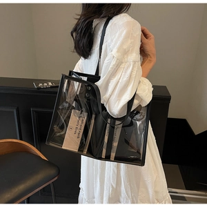 Détail d'un cabas transparent en PVC avec bandoulières noires et carte intérieure