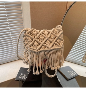 Détail du sac bandoulière beige tissé à la main avec glands bohèmes et motifs losanges ajourés