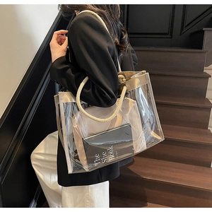 Detailed view of transparent PVC tote bag with rope handles held by a model in a suit