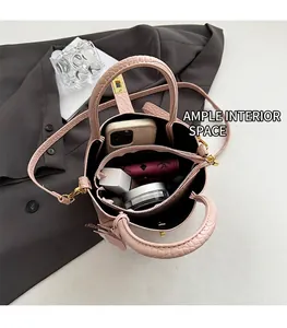 Interno spazioso della borsa a secchiello rosa a coccodrillo con telefono e trucchi