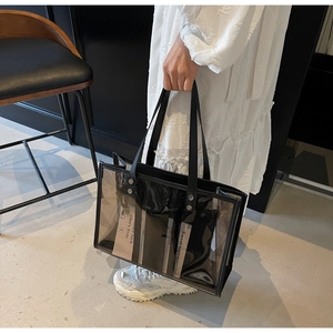 Détail d'un sac cabas transparent en PVC avec bordure en cuir noir et pochette interne