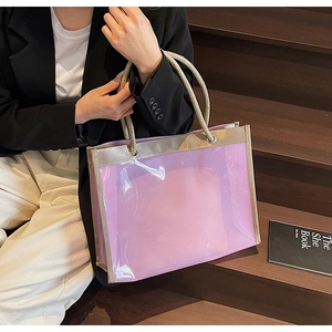 Detail of purple transparent PVC tote bag with woven handles and golden trim edge