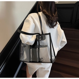 Detail of transparent PVC tote bag with black leather trim and inner zipper pouch