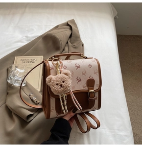 Detailansicht eines Vintage-Canvas-Rucksacks mit Hirschmuster und Plüschbär-Anhänger
