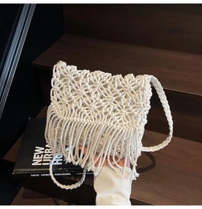 Vue détaillée du sac à franges blanc tissé à la main avec motifs ajourés sur escalier